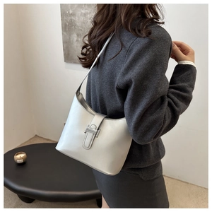 Close-up of a silver metallic shoulder bag with a sleek buckle and premium texture