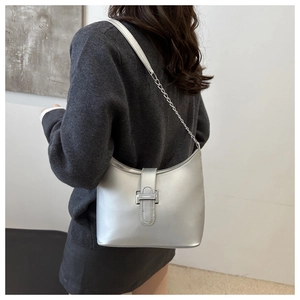 Silver metallic underarm bag with H-shaped buckle and leather chain strap shown on model