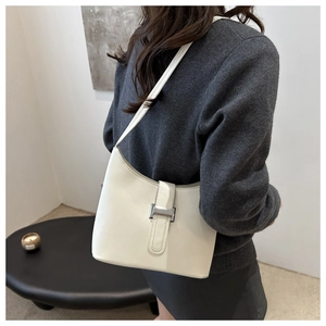Detailed view of a chic beige underarm bag with silver buckle and sleek leather texture