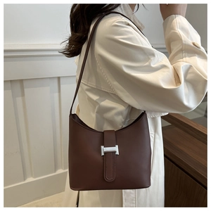 Deep brown matte leather underarm bag with silver buckle worn with a beige trench coat