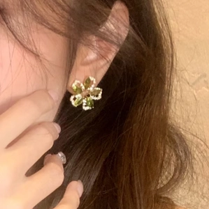 Olive green floral earrings with cubic zirconia petals worn on ear for a natural look