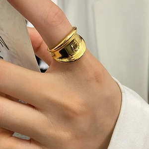 Macro detail of polished 18K gold irregular wave ring with minimalist aesthetic on model