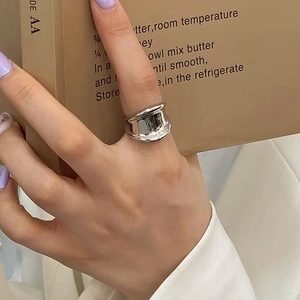 Close-up of wide irregular silver ring on model hand over a vintage book page