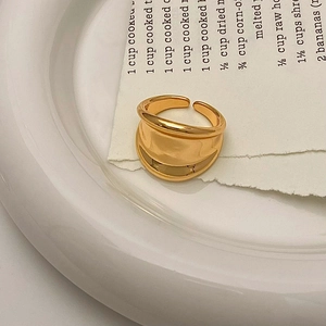 Macro shot of minimalist gold layered irregular ring on a vintage aesthetic background