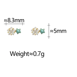 Detail view of dainty gold star stud earrings with blue enamel and crystal accents