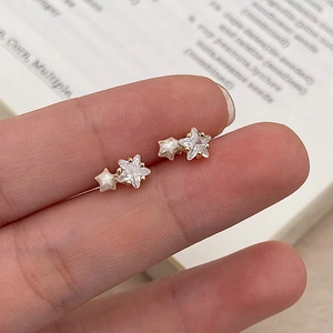 Close-up of star earrings with sparkling cubic zirconia and pearl finish details