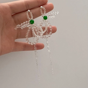 Detail of beaded tassel earrings with crystal bows and long silver hanging chains