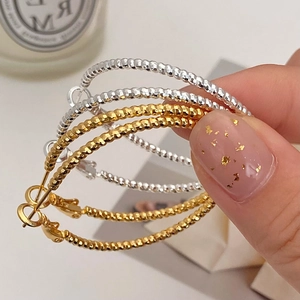 Textured gold and silver hoop earrings with starlight beaded finish in luxury style