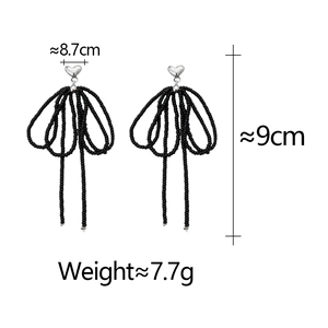 Detail of beaded heart bow earrings showing 9cm length and 7.7g weight dimensions