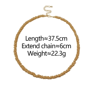 Detailed close-up of gold beaded necklace with spiral texture and adjustable lobster clasp