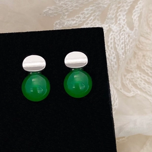 Close-up of green chalcedony stud earrings with silver geometric top on black velvet