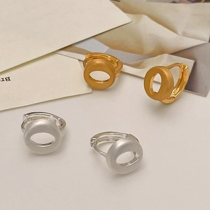 Detail view of round 18K gold and silver plated earrings with matte brushed finish