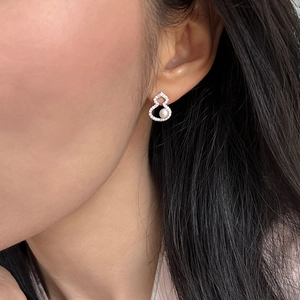 Nahaufnahme der eleganten Zirkon Wulu Ohrstecker mit weißer Perle am Modellohr