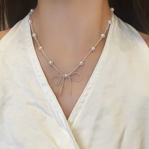 Elegant beaded pearl necklace with bowknot pendant on model neck for french style