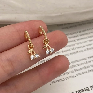 Détails des boucles d'oreilles cerises dorées avec zircons et cercles perlés