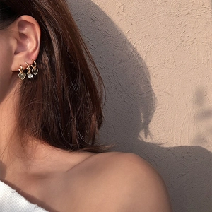 Lot de trois créoles dorées avec breloques cœur et cristaux de zircon portées à l'oreille