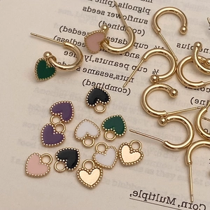 Détail de l'ensemble de boucles d'oreilles cœur dorées avec pendentifs émaillés