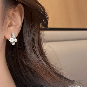 Elegante Blumenohrstecker mit weißen Blüten und Perlen am Modell für einen stilvollen Look