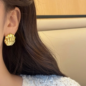 Vista dettagliata degli orecchini a conchiglia placcati oro 18K con trama a righe