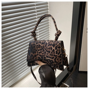 Détail du sac bandoulière léopard avec poignée nouée et finitions métalliques dorées