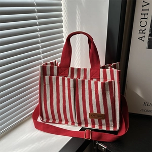 Red and white striped canvas tote bag with adjustable shoulder strap and leather detail