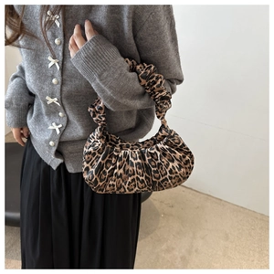 Détail d'un sac à main léopard tendance avec un design plissé et une texture douce