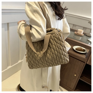 Detail of khaki quilted tote bag with unique braided texture and wide shoulder strap