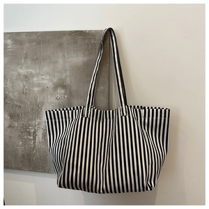 Gros plan sur la texture en toile à rayures verticales noires et blanches du sac