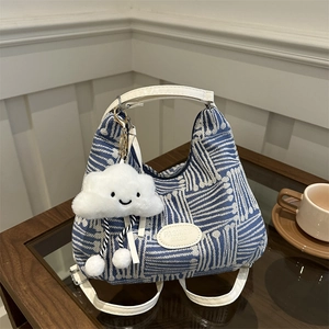 Blue and white geometric knit tote bag with adjustable straps and cloud charm accessory