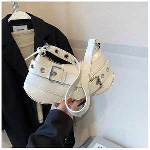 Detail of white vintage baguette bag with decorative straps and silver metal buckles