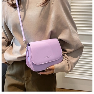 Detail of light purple saddle bag with fashion trend lettering and adjustable strap