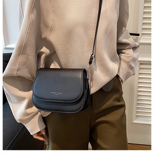 Vue détaillée de la sacoche noire avec texte tendance pour une tenue de bureau chic