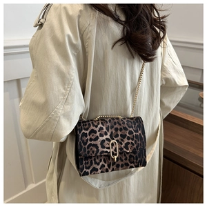 Detail of leopard print crossbody bag with gold chain strap and stylish paperclip buckle