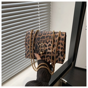 Close-up of leopard print crossbody bag with gold chain strap and ring clasp detail