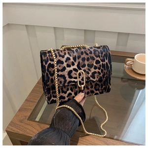 Detail of leopard print crossbody bag with gold chain strap and metallic lock clasp