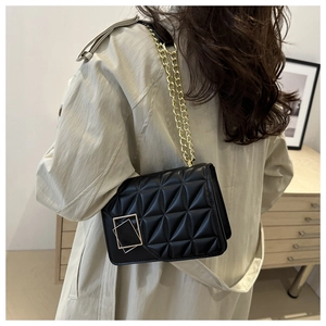 Detail showing classic quilted texture and gold chain strap of the black crossbody bag