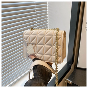 Close-up of cream quilted leather small square bag with golden chain strap and buckle