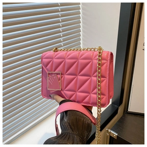 Close-up of Barbie pink quilted crossbody bag with golden chain strap and buckle
