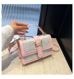 Detail of pink leather handbag showing butterfly embroidery and gold metal hardware