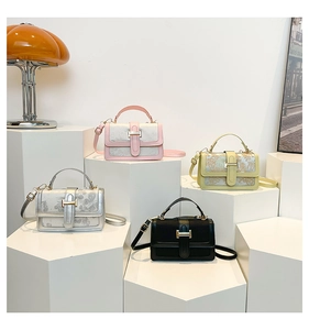 Detail of vintage square crossbody bags with H-shaped gold metal buckles in various colors