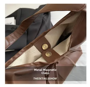 Macro detail of high-quality magnetic metal buckle on a brown pleated tote bag