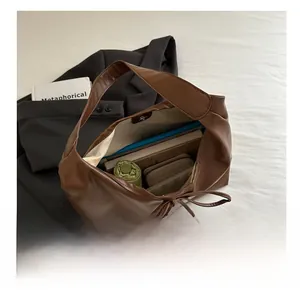 Close-up of brown tote bag interior showing large capacity for books and umbrella