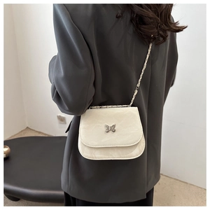 Detail of a chic butterfly chain bag in creamy white with a premium leather texture