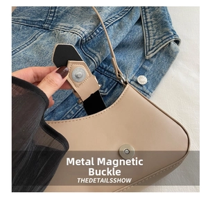 Detail showing the magnetic hardware closure on a beige leather crescent shoulder bag