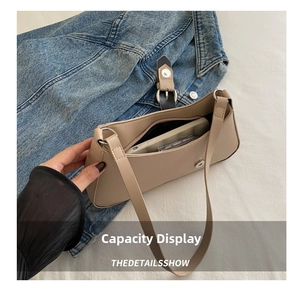 Beige crescent bag capacity view showing phone storage on denim and white fabric