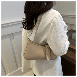Chic cream baguette shoulder bag featuring silver buckle detail shown on a female model