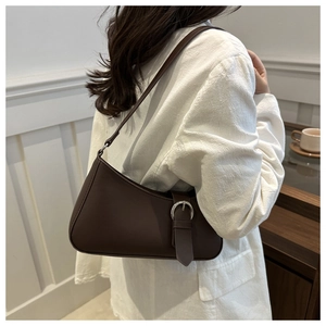 Close-up of vintage dark brown faux leather shoulder bag with silver buckle accent