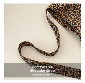 Detail of wide shoulder strap on leopard print canvas bag with durable texture