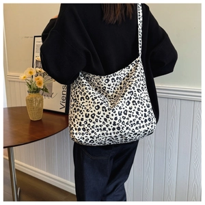 Detailed view of the black and white leopard print canvas tote bag with wide shoulder strap