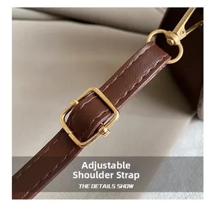 Detail of adjustable coffee leather strap with golden buckle and lobster clasp hardware
